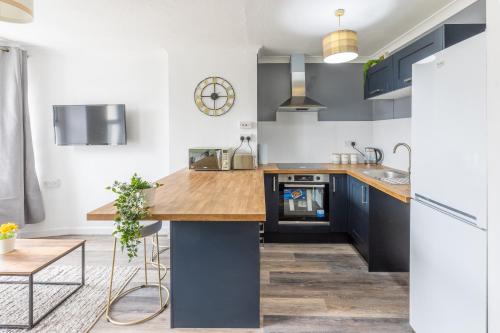 a kitchen with blue cabinets and a wooden counter top at Queen Street Apartments in Whitehaven