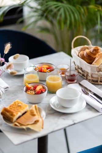 a table with breakfast foods and drinks on it at La Maison des Embruns in Plouarzel