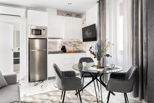 a kitchen with a table and chairs and a refrigerator at Apartamentos Casa del Arco de 2 a 6 personas in Andújar