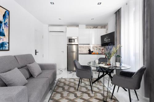 a living room with a couch and a table with chairs at Apartamentos Casa del Arco de 2 a 6 personas in Andújar