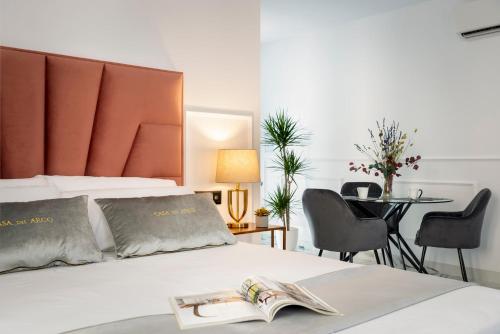 a bedroom with a bed with a book on it at Apartamentos Casa del Arco de 2 a 6 personas in Andújar