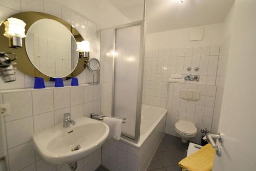 a bathroom with a sink and a toilet and a mirror at Haus Nordseebrandung NB36 in Cuxhaven