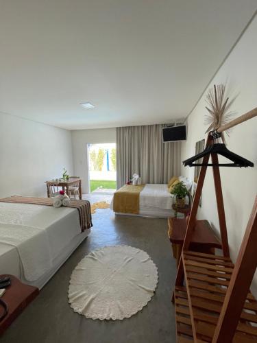 a hotel room with two beds and a television at Sollaris Ecopousada in Japaratinga