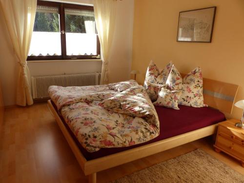 een slaapkamer met een bed met kussens en een raam bij Ferienwohnung Allgäuer Bergwelt in Immenstadt im Allgäu
