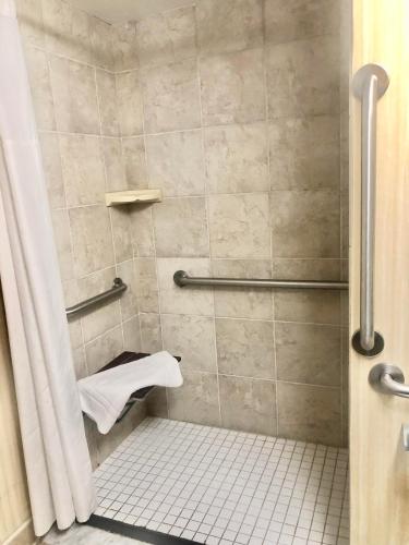 a bathroom with a shower with a white towel at The Barclay Towers Hotel and Resort in Virginia Beach