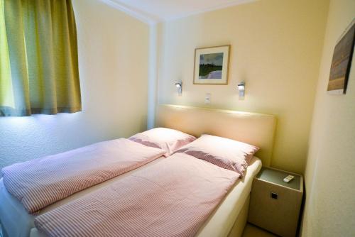 a small bedroom with a bed with lights on it at Strandhochhaus SD06 in Cuxhaven