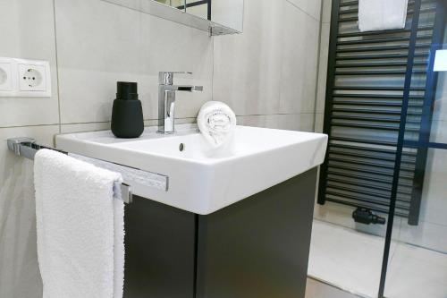 a bathroom with a white sink and a mirror at Strandhochhaus SHC2 in Cuxhaven