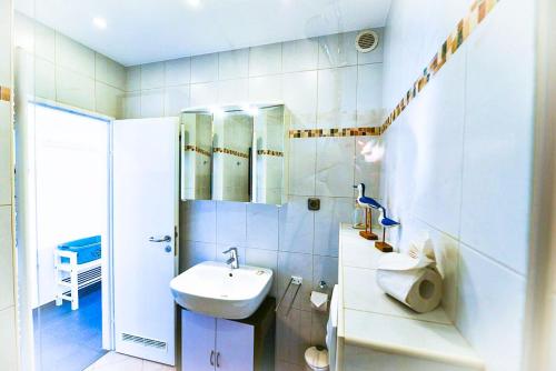a white bathroom with a sink and a mirror at Strandhochhaus SD09 in Cuxhaven
