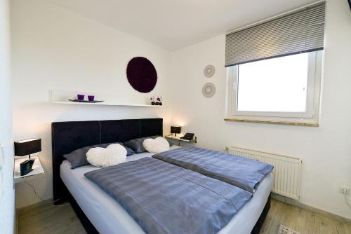 a bedroom with a bed with two pillows and a window at Strandhochhaus SF10 in Cuxhaven