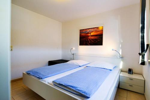 Schlafzimmer mit einem Bett mit Wandgemälde in der Unterkunft Haus Horizont HZ09 in Cuxhaven