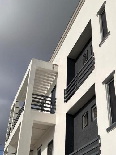 a white building with balconies on the side of it at Luxury Studio Flat With Pool at Kingsland Lekki in Igboefon