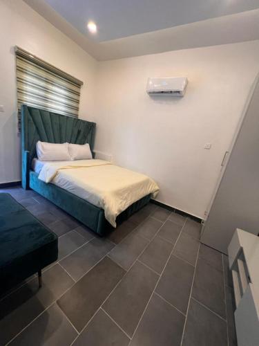 a small bedroom with a bed and a window at Luxury Studio Flat With Pool at Kingsland Lekki in Igboefon
