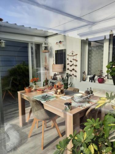 - une table en bois sur une terrasse avec une table dans l'établissement Mon petit paradis, à Berck-sur-Mer