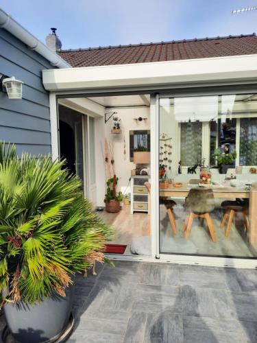 une porte coulissante en verre de la cuisine avec une table à manger. dans l'établissement Mon petit paradis, à Berck-sur-Mer