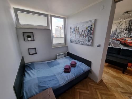 um quarto com uma cama azul com duas almofadas vermelhas em Centrum Warszawa - Center of Warsaw em Varsóvia