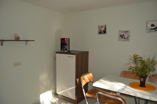 a kitchen with a table and a white refrigerator at Ferienwohnung am Storchennest in Burkau in Burkau
