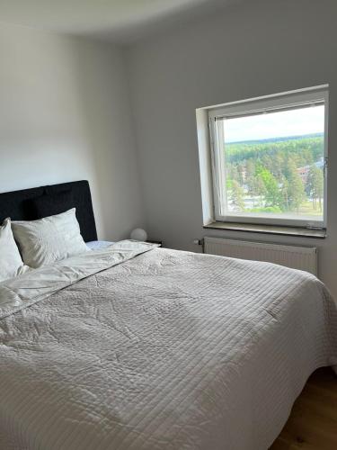 a white bed in a bedroom with a window at Elme apartment in Växjö