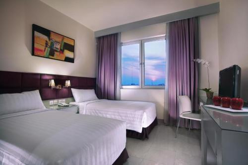 Postel nebo postele na pokoji v ubytování Royal Palm Hotel & Conference Center Cengkareng