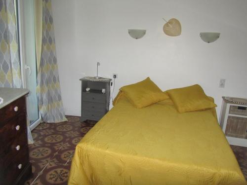 Un dormitorio con una gran cama amarilla con sábanas amarillas. en Chez Tania, en Vallon-Pont-dʼArc