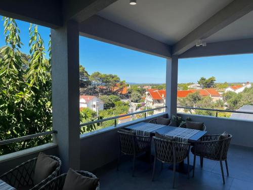 a balcony with a table and chairs and a view at MEMORI bed&breakfast in Rab