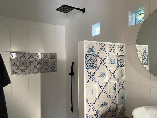 a bathroom with blue and white tiles on the wall at Arthouse Lola in Bergen