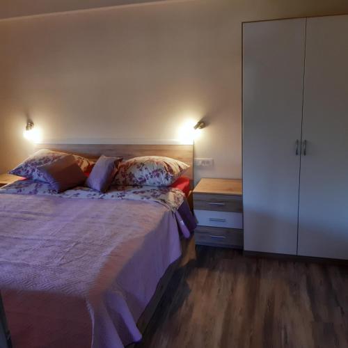 a bedroom with a bed with two pillows and a cabinet at APARTMA in SOBE PILIH in Vipava