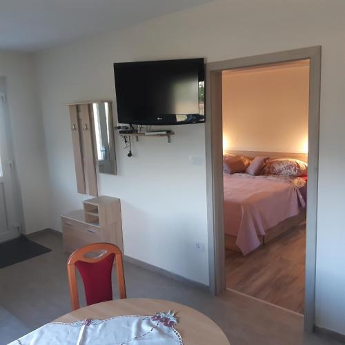 a bedroom with a bed and a flat screen tv at APARTMA in SOBE PILIH in Vipava