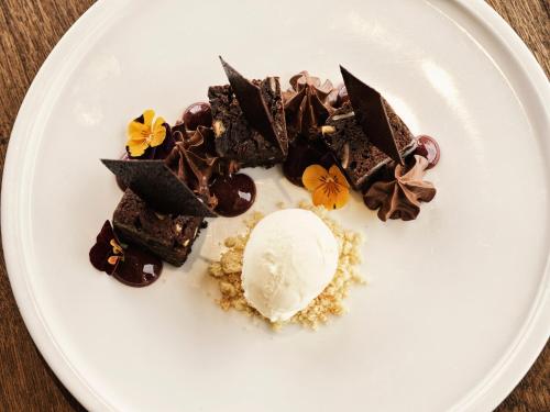 a white plate with chocolate desserts and an ice cream at Mykonos Earth Suites in Mýkonos City
