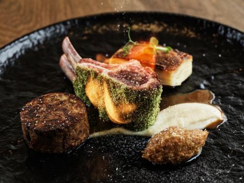a plate of food with meat and vegetables on it at Mykonos Earth Suites in Mýkonos City
