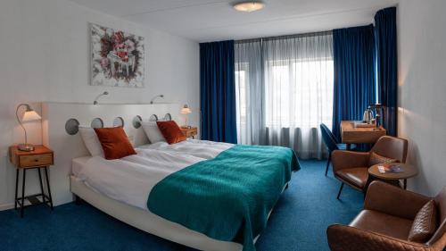 ヘーグにあるDe Watersport Heegの大きなベッドと椅子2脚が備わるホテルルームです。