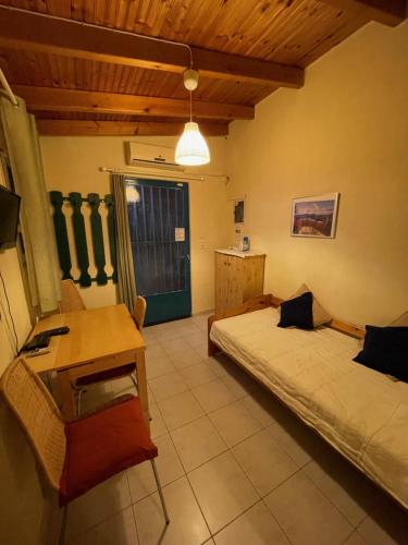 a bedroom with two beds and a table and a desk at Maria`s Haus in Artemida in Artemida