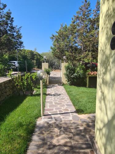 un passaggio in pietra che conduce a un cortile con cancello di Appartamento La Pergola a Cala Liberotto