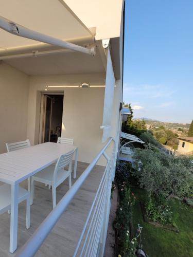 a patio with a table and chairs on a balcony at Garda view - Nuovo appartamento con solarium vista lago in Garda