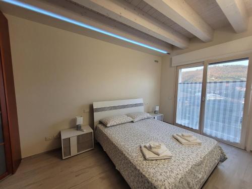 Een bed of bedden in een kamer bij Garda view - Nuovo appartamento con solarium vista lago