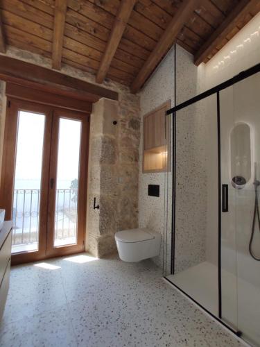 a bathroom with a toilet and a glass shower at Casa Lagarto, (Ribeira Sacra), Taboada in Taboada