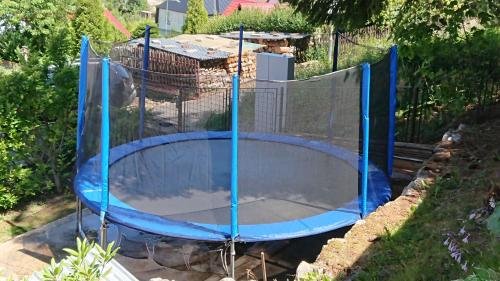 a blue trampoline in a yard with a fence at Chalupa Krušné hory in Potŭčky