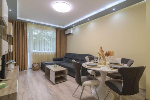 a living room with a blue couch and a table at Chayka Comfort Apartment in Varna City