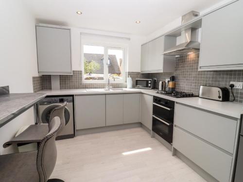 a kitchen with white cabinets and a stove top oven at 3 Granbrook Lane in Chipping Campden