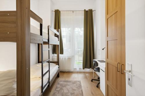 um quarto com beliches, uma secretária e uma janela em Lux Apartment in Charlottenberg em Berlim