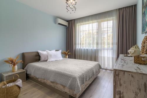 a bedroom with a bed and a large window at Chayka Comfort Apartment in Varna City