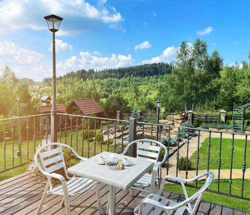 a table and chairs on a deck with a view at Villa Zoryany Dvir in Skhidnitsa