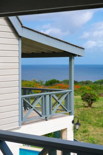 a balcony with a view of the ocean and flowers at West Rock Villas in Saint James
