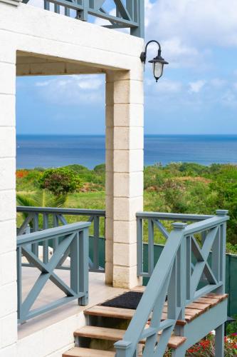 a blue stairway with a view of the ocean at West Rock Villas in Saint James