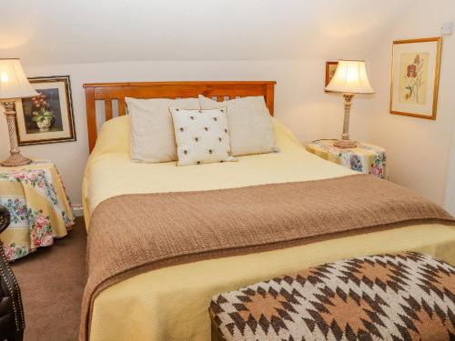 a bedroom with a bed with pillows and two lamps at Little London in Battle