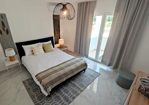 a bedroom with a bed and a large window at Villa Olive Hill in Dobra Voda
