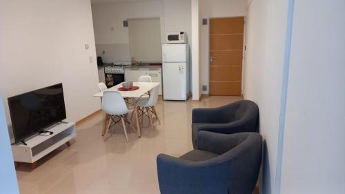 a living room with a table and chairs and a television at SanPier - Alquileres Temporarios in Neuquén