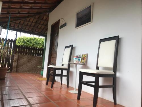 2 Stühle und ein Tisch mit 2 Spiegeln an der Wand in der Unterkunft Aláfia Comandatuba in Una