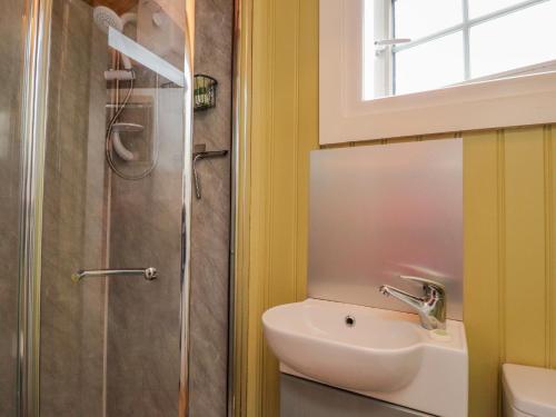 een badkamer met een wastafel en een douche bij Bracken Hut at Copy House Hideaway in Barnoldswick