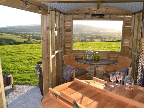a wooden cabin with a table and a window at Heather Hut at Copy House Hideaway in Barnoldswick