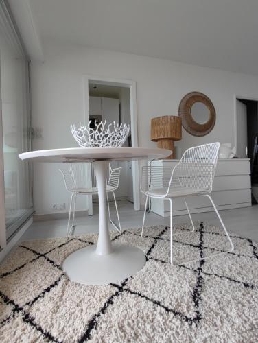 une salle à manger avec une table et des chaises sur un tapis dans l'établissement LA SUITE appartement pleine vue mer, à Concarneau
